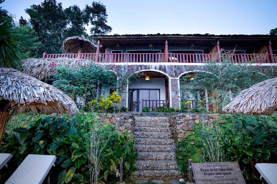 Explore a tropical villa surrounded by lush greenery and vibrant flowers, featuring rustic architecture and peaceful ambiance.