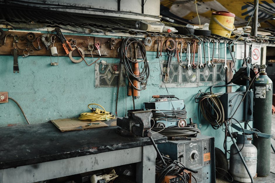 A cluttered workshop space with tools, machinery, and a vise, creating an industrial vibe.