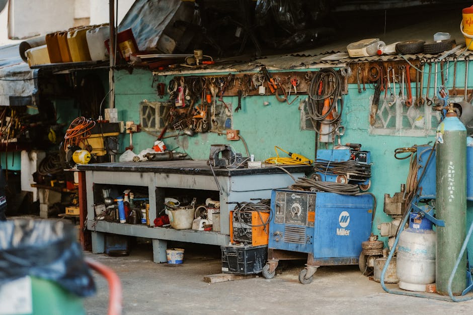 A cluttered workshop with tools, welding equipment, and storage solutions.