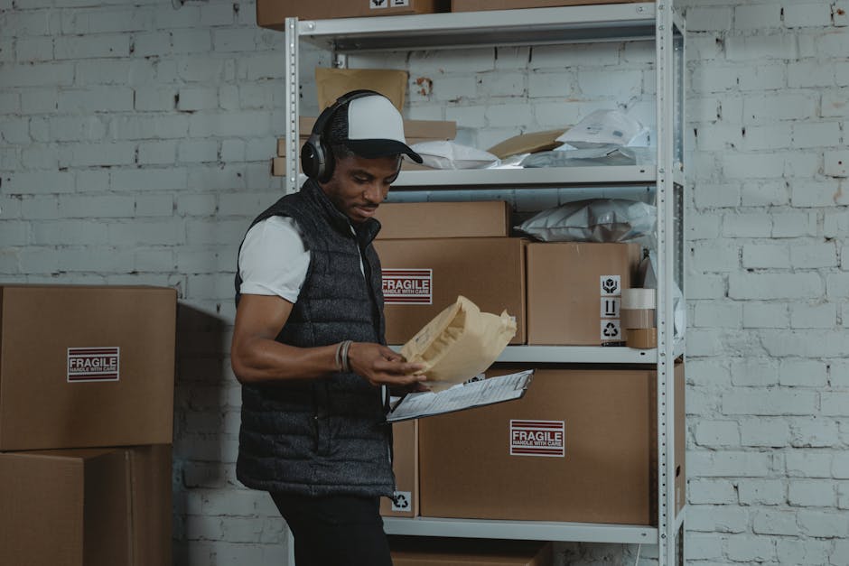 Warehouse worker sorting packages in an industrial environment with headphones on, focused and diligent.